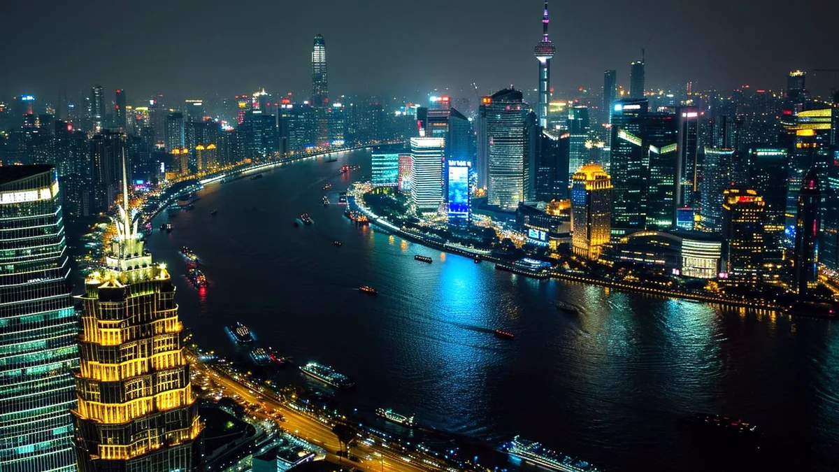 Glass towers of the Shanghai Bund glow along the Huangpu River at night.