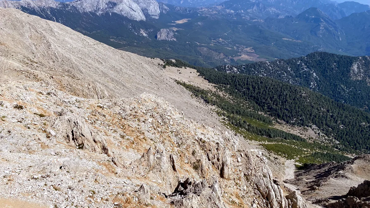 A rocky ridge of the Taurus range climbs toward snow caps at midday.
