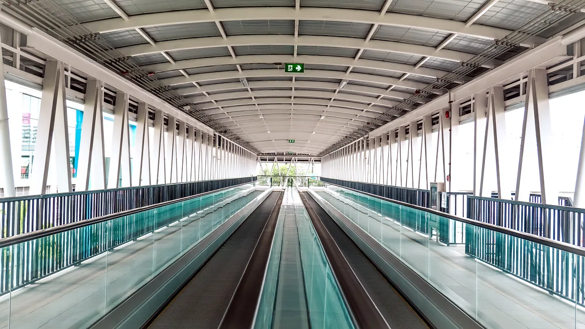 A boarding bridge connects to a wide body jet parked at the gate.