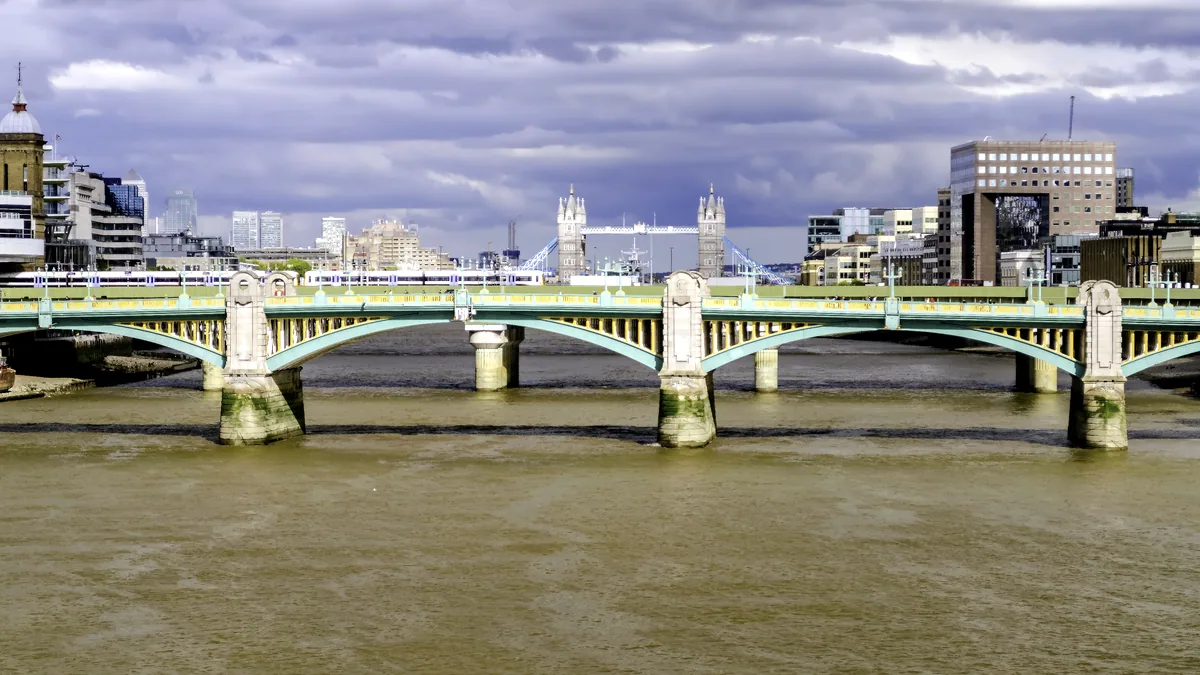 The Thames runs past a London bridge on a grey but bright winter day.